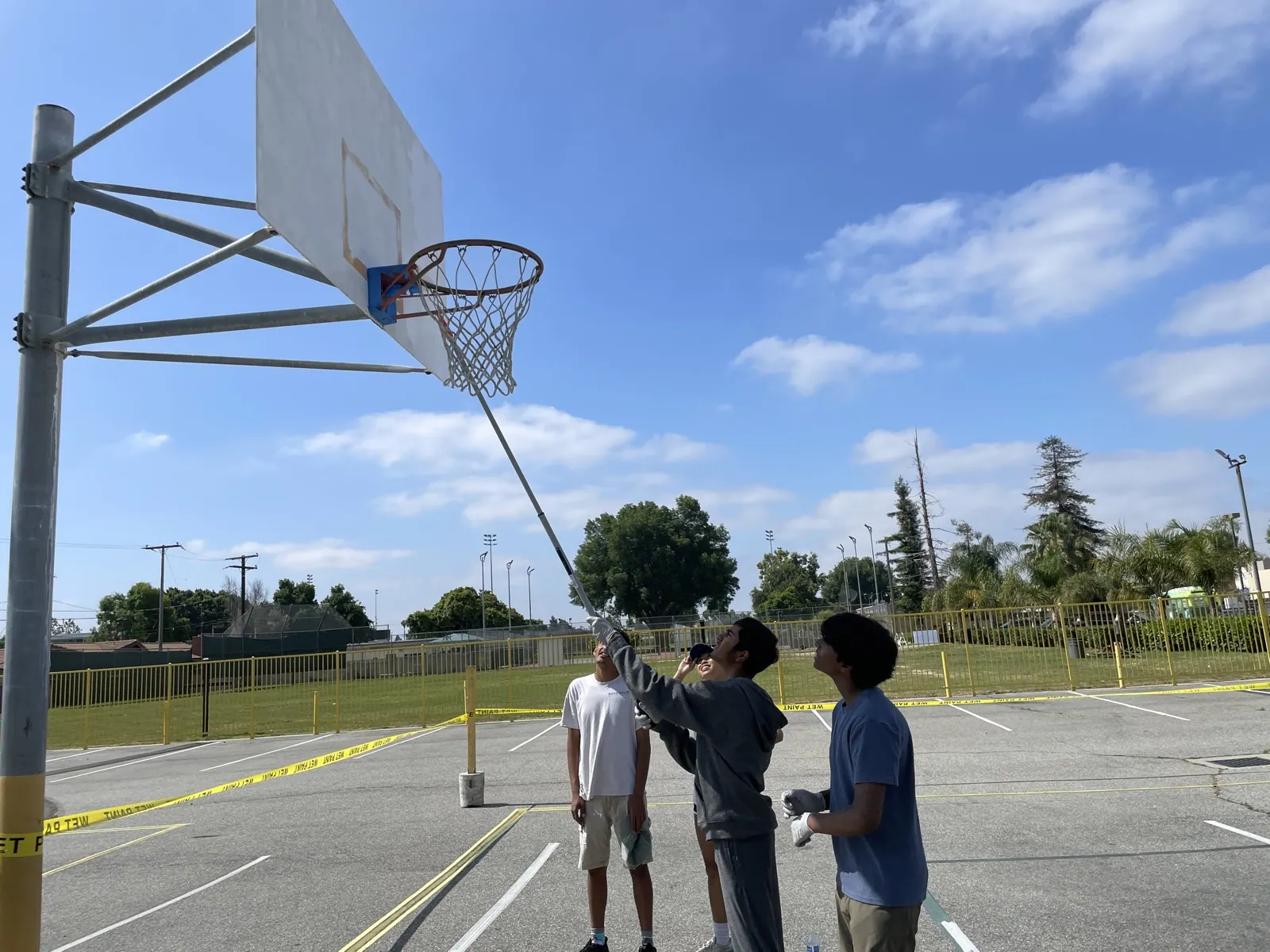 Student volunteers repainting a community basketball court